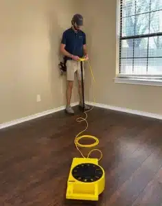 A home inspector in Grapevine, TX sets up a foundation elevation measurement tool inside a home